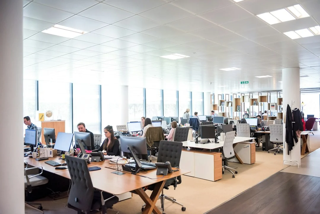 Team working at desks in a busy open-plan office, like the Winston-Salem businesses we answer for