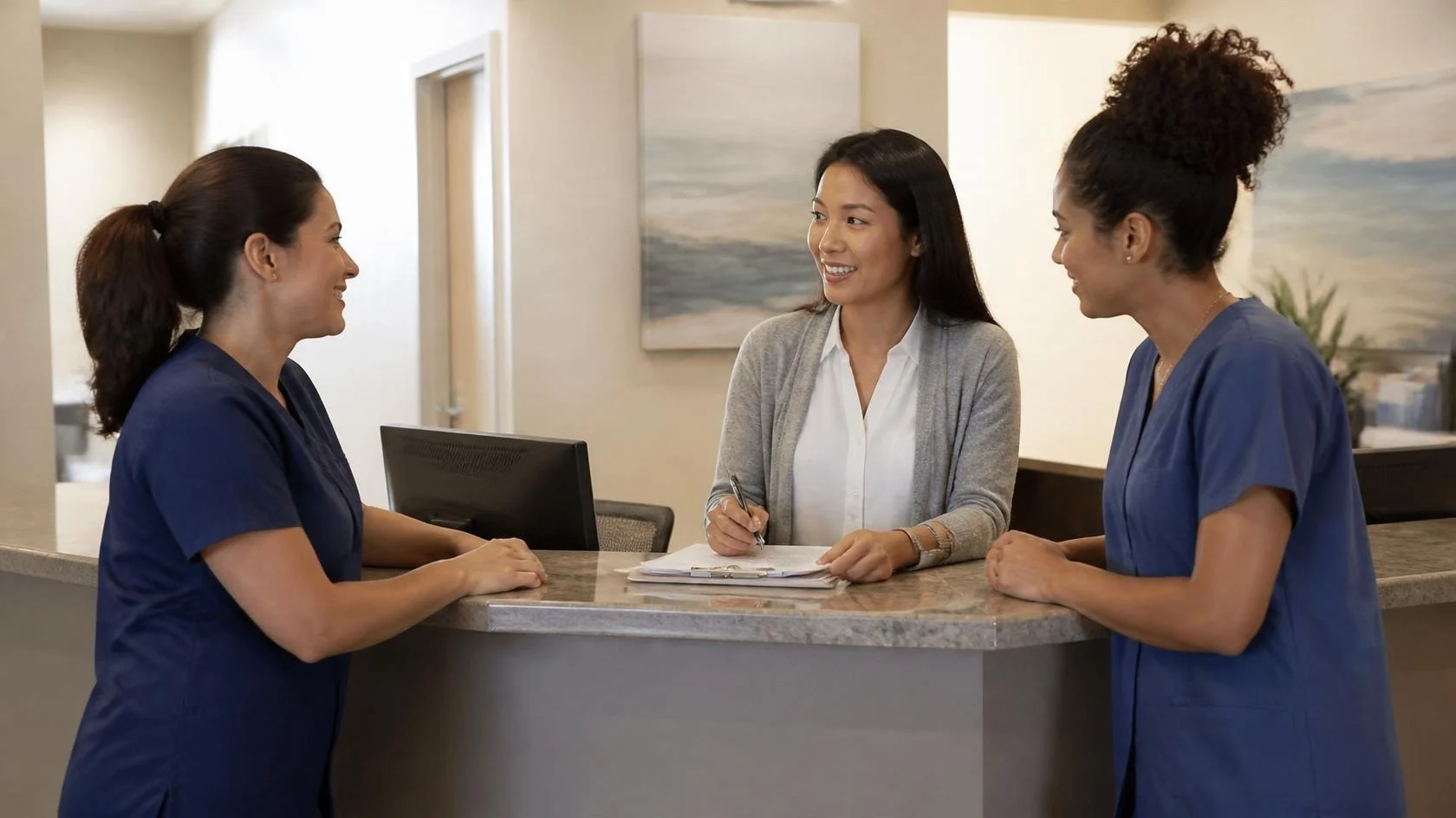 Medical front desk team planning together at the reception counter of a Tampa practice
