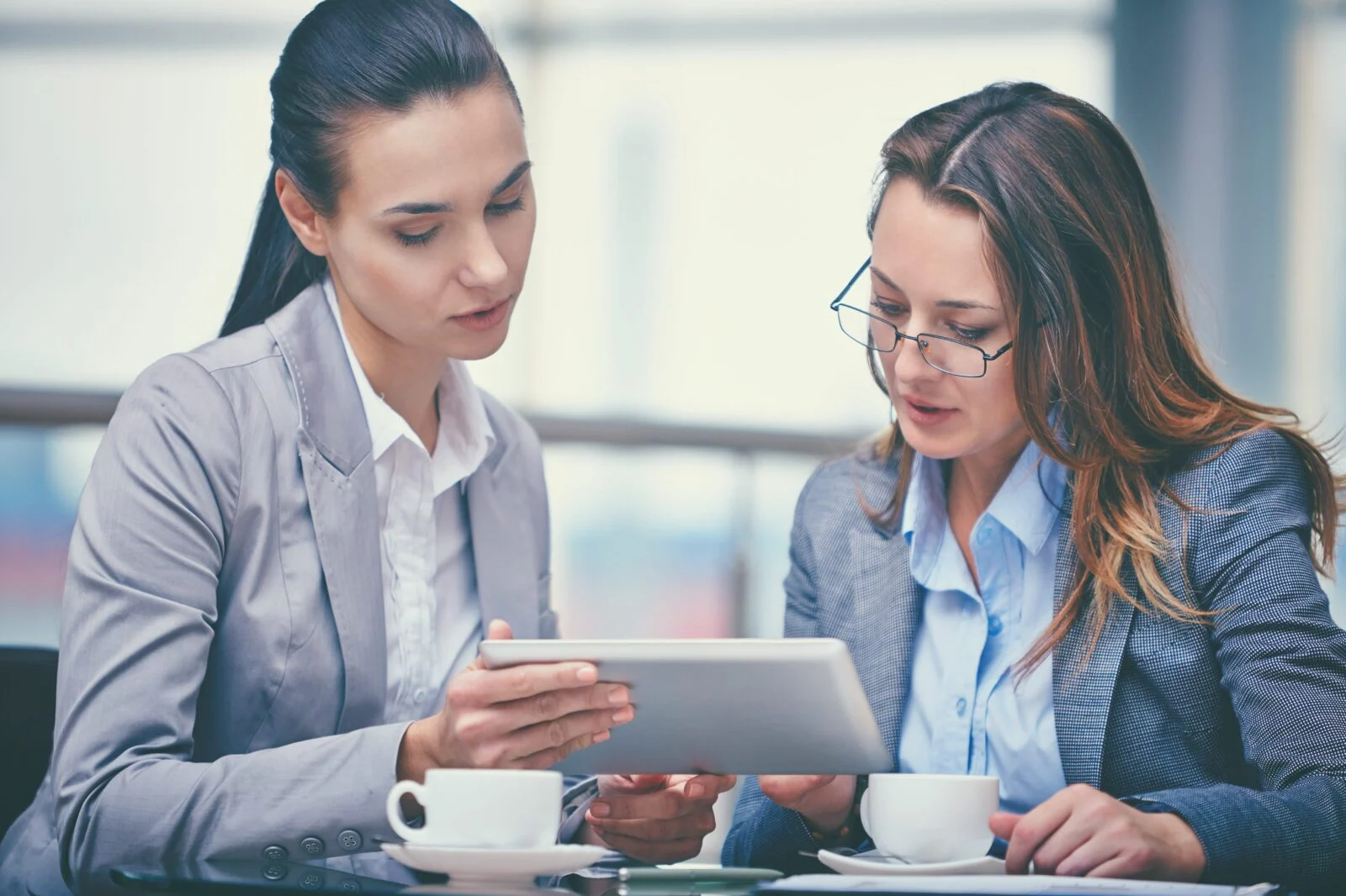 Two small business professionals reviewing their phone coverage plan on a tablet